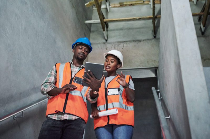 Shot of a young man and woman using a digital tablet while working at a construction site.